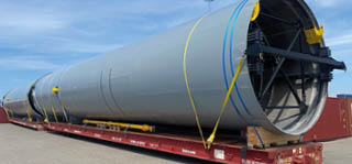 A large blue and yellow tube is on a red truck. Beskrivelse genereret af AI